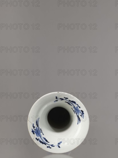 Vase, Japanese, Edo period 1603–1868, Genroku–Kyoho eras ca. 1690–1730, Arita blue-and-white porcelain vessel, decorated with phoenixes hoo, hares/rabbits, peonies, chrysanthemums, lotuses — kacho flowers-and-birds / kachoga iconography; one of four elements of a set SKAZsz 314/1–4; height 39.0 cm, diameter 20.3 cm., A top-down view of a white ceramic vessel with a dark interior and a rim decorated with blue floral motifs, set against a smooth gray background; the rim shows a visible crack and subtle surface imperfections, and the dominant colors visible are white, blue, dark black inside the vessel, and gray in the background.