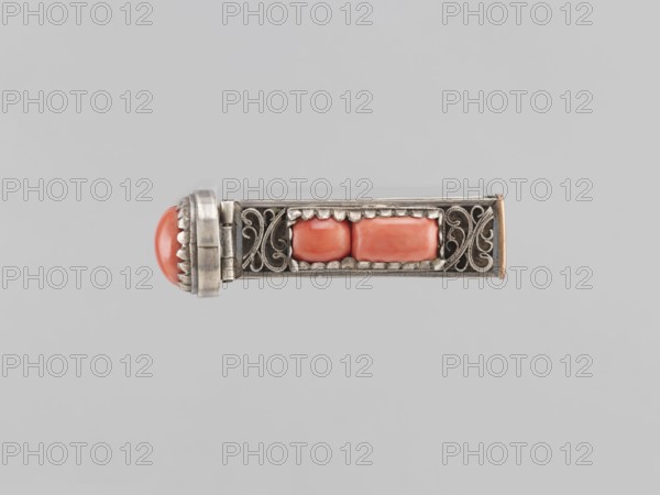 Braid clasp, braid ornaments, clasps, jewelry; Mongolian art, artistic crafts, women's ornaments; late 19th century; Mongolia; materials: jewelry; dimensions: height 2.9 cm, width 2.3 cm, length 7.4 cm., A rectangular metallic object with ornate filigree sides and a hinged rounded end, featuring a domed coral-colored stone at one end and two coral-colored rectangular stones set in the center, all framed by silvery metal with decorative scalloped and scrollwork details; the visible colors are coral, silver, and small touches of warm metallic brown against a pale gray background.
