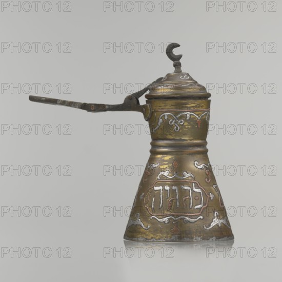Coffee pot, Arabic and Jewish cultural associations; beverages, coffee, cezve vessel; Decoration: Hebrew inscriptions inlaid in copper, Star of Solomon motif, arabesque patterns; hinged lid with hinge halfway down the handle, lid topped with a crescent. Inscriptions Hebrew read: drinking; in the hexagonal star Gan Eden, garden; in the cartouche for celebration; under the handle, in the Seal of Solomon/Star of David Mim from the word water. Beginning of the 20th century, Palestine; vessel; height 15.5 cm, width 15.5 cm, diameter 8.7 cm., A conical metal vessel with a hinged domed lid topped by a crescent-shaped finial, shown in profile with a long slender handle extending sideways; the surface is a mix of brass-like gold and darker brown patina with areas of silver and copper-toned decorative inlay, featuring ornate scrollwork and ornamental motifs around the body and neck; the handle appears dark and worn with spots of lighter discoloration; the background is a smooth pale gray.