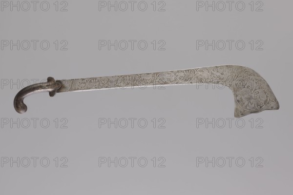 Sabre of the bark type, Indian culture. With a curved hilt and a similarly expanded engraving. Decorated with representations of animals: lions, a horse, a rhinoceros, a camel, elephants, a hare, and a plant twig; zoomorphic motifs. Bark weapon, weaponry. 1st half 20th century. India possibly or Nepal possibly. Height 69.0 cm, width 14.5 cm., A long metal blade with a curved dark handle and a hooked pommel lies horizontally against a pale gray background; the blade shows etched decorative patterns of flowing vines and floral motifs and a stylized scene near the broader end, with visible colors including silvery metal tones, darker gray on the handle, and the pale gray background.