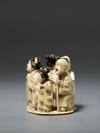 Okimono in the shape of a group of six singing people; unknown creator; Japanese, Meiji late 19th century; figurines, okimono, musicians; depiction: a courtesan with a small kamuro servant, a townswoman carrying a lantern, a wealthy merchant with a fan, a messenger with an oblong box, and a blind Buddhist monk with a shaved head leaning on a cane; sculpture; height 5.1 cm, width 5.2 cm, depth 4.5 cm., A small carved group of figures arranged in a circular composition, primarily in an off-white or cream color with darker brown and black accents; the figures wear flowing robes with carved patterns and textured hair, including a figure holding a staff and a figure with a rounded, open-mouthed expression; a few figures have hair styled in topknots or buns with dark coloring, and there are subtle brownish shading and fine engraved details on the robes and faces; the piece sits on a low round base and is photographed against a gradient gray background ranging from dark gray at the top to lig...