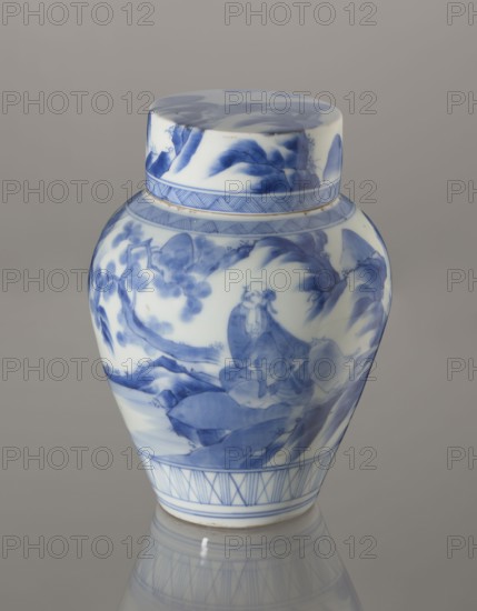 Storage Vessel with Lid, Zôshuntei Sanpo 1841–1878. Storage pot, blue-and-white porcelain, Japanese; Arita; c. 1842–1878. Pear-shaped vessel with flat cylindrical lid. Decorated in a Chinese-style landscape: an old man resting under a pine on a rocky cliff overlooking a wide body of water, with mountainous scenery, a waterfall, lofty peaks, and distant boat sails; pines, mountains, waterfalls, sages; kachôga bird-and-flower/iconography influence. Lower base has a wide ornamental band of three vertical and two crossed lines; neck and lower edge of lid have diagonal-line bands forming triangular forms; lid decorated with a rock motif. Decoration modeled on Chinese Southern School painting that influenced Japanese bunjinga nanga; free-form painting with precise, masterful lines. Cobalt in bright, pure shades in several tones. Underglaze cobalt signature on the base: Zoshuntei Sampo zo made by Zoshuntei Sampo. Height 21.8 cm; diameter 15.3 cm., A porcelain jar with a lid sits against a neu...