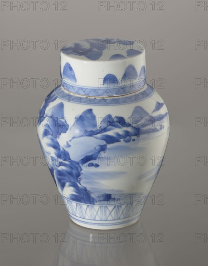 Storage vessel with lid by Zôshuntei Sanpo Zoshuntei Sampo, c. 1842–1878, Arita, Japan. Blue-and-white porcelain pear-shaped vessel with flat cylindrical lid; height 21.8 cm, diameter 15.3 cm. Decorated in cobalt in several tones with a Chinese-style landscape: an old man resting under a pine on a rocky cliff overlooking water, mountains, a waterfall, and distant boat sails; lower base band of three vertical and two crossed lines; neck and lower lid edged with diagonal-line bands forming triangular motifs; lid decorated with a rock motif. Decoration modeled on Chinese Southern School painting, related to Japanese bunjinga/nanga; free-form painting and finely executed lines indicate a highly skilled porcelain decorator. Underglaze cobalt signature on the base: Zoshuntei Sampo zo made by Zoshuntei Sampo. Subjects/iconography: pines, mountains, waterfalls, sages; classification: storage pot, kachôga iconography., A porcelain jar with a lid featuring blue painted landscape-like brushwork o...