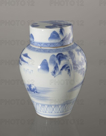Storage Vessel with Lid, Zôshuntei Sanpo 1841–1878. Storage pot, blue-and-white porcelain, Japanese; Arita, c. 1842–1878. Pear-shaped vessel with flat cylindrical lid. Decorated in a Chinese-style landscape: an old man resting under a pine on a rocky cliff overlooking a wide body of water, with mountainous scenery, a waterfall, lofty peaks, and distant boat sails. Lower base bears a wide ornamental band of three vertical and two crossed lines; neck and lower lid edge have diagonal-line bands forming triangular motifs. Lid decorated with a rock motif. Decoration modeled on Chinese Southern School painting, influencing Japanese bunjinga nanga; free-form painting with precise, masterful lines. Cobalt in bright, pure shades in several tones. Underglaze cobalt signature on the base: Zoshuntei Sampo zo made by Zoshuntei Sampo. Height 21.8 cm; diameter 15.3 cm., A lidded porcelain jar with a glossy white surface decorated in blue, showing a rounded body that tapers toward the base and a match...