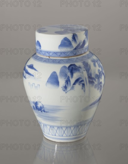 Storage vessel with lid, by Zôshuntei Sanpô Zoshuntei Sampo signed underglaze in cobalt: Zoshuntei Sampo zo; c. 1842–1878, Arita, Japan. Blue-and-white porcelain, pear-shaped with flat cylindrical lid; height 21.8 cm, diameter 15.3 cm. Decorated in Chinese-style landscape after Southern School painting—an old man resting under a pine on a rocky cliff overlooking a wide body of water with mountain peaks, a waterfall, and boat sails on the horizon. Lower base has a wide ornamental band of three vertical and two crossed lines; neck and lower edge of lid feature diagonal-line bands forming triangular forms; lid decorated with a rock motif. Motif recalls themes of Edo/Meiji-period bunjinga nanga. Cobalt in a bright, pure shade applied in several tones; free-form painting with precise, masterful lines indicating a highly skilled porcelain decorator., A lidded ceramic jar with a rounded body and short neck sits against a plain gray background, glazed in white with blue painted scenes and deco...
