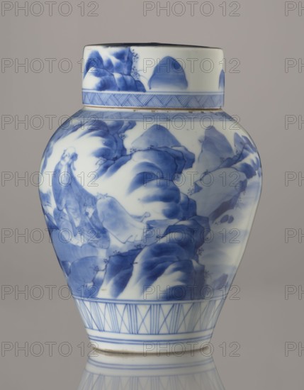 Storage vessel with lid, Zôshuntei Sanpo signed Zoshuntei Sampo zo, c. 1842–1878, Arita, Japan. Pear-shaped blue-and-white porcelain storage pot with flat cylindrical lid. Decorated in cobalt in several tones with a Chinese-style landscape: an old man resting under a pine on a rocky cliff overlooking a broad body of water, with a waterfall, lofty peaks, and distant sails; pines, mountains, waterfalls, and sages rendered in a style modeled on Chinese Southern School painting and related to the bunjinga nanga movement. Lower base band of three vertical and two crossed lines; diagonal-line ornamental bands forming triangular motifs at the neck and lid edge; lid decorated with a rock motif. Free-form painting with precise, masterful lines indicating an excellent porcelain decorator. Height 21.8 cm; diameter 15.3 cm., A porcelain jar with a lid shown against a neutral gray background, decorated in blue on a white ground; the jar has a bulbous body tapering toward a narrow base and a short c...