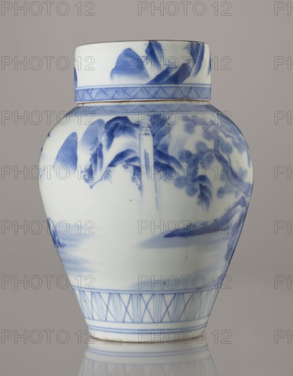 Storage vessel with lid, by Zôshuntei Sanpo c. 1842–1878. Pear-shaped blue-and-white porcelain with flat cylindrical lid; height 21.8 cm, diameter 15.3 cm; Arita, Japan; Edo–Meiji period. Decorated in cobalt in several tones with a Chinese-style landscape: an old man resting under a pine on a rocky cliff overlooking a broad expanse of water, with waterfall, lofty peaks, and boat sails on the horizon. Lower base features a wide ornamental band of three vertical and two crossed lines; neck and lower edge of lid have diagonal-line bands forming triangular motifs; lid shows a rock motif. Decoration modeled on Southern School Chinese painting and Japanese bunjinga nanga influence; free-form painting with precise, masterful lines. Underglaze cobalt signature on the base: Zoshuntei Sampo zo made by Zoshuntei Sampo., A ceramic jar with a rounded body and a separate lid, decorated in blue on a white ground. The surface shows brush-painted landscape motifs including stylized mountains, trees, an...