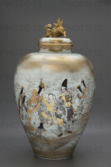Vase with cover, Kanzan, Denshichi 1821–1890 creator, Japanese, Meiji period late 19th century; ceramics; ovoid vase with gently upward-flaring belly, narrow distinct foot and short narrow collar; iconography: karashishi lions and rakan; vessel height 61 cm, diameter 34.5 cm., A tall ceramic jar with a lid topped by a gold sculpted creature sits against a neutral gray background; the jar surface shows a palette of white, cream, gold, black, and gray with areas of pale brownish-gold wash near the top and base. The body of the jar is decorated with a painted scene featuring a group of figures in flowing robes rendered in black and gray line work, with several areas highlighted in metallic gold on garments and accessories. The figures include both standing and seated poses, some wearing ornate headpieces and one wearing a tall dark hat, and their faces and hair are depicted in fine black lines and pale tones. The lid has a band of gold decoration and the sculpted creature on top is entire...