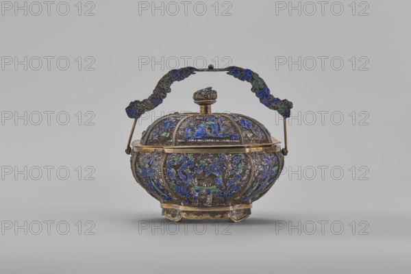 Basket with a lid; maker, Chinese; 19th century, Canton, China; container; decorated with flowers and ornaments; height 9.8 cm, width 10.5 cm, depth 7.5 cm., An ornate metal container with a rounded body and domed lid sits centered against a plain light gray background; the container features an arched handle attached at each side with decorative panels, and the surface is richly decorated with raised filigree and enamel in shades of blue and green accented by metallic gold and dark silver tones, with floral and scroll motifs covering the body and lid and a small sculpted finial on top, all resting on a short decorative base with small feet.