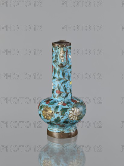 Vase, cloisonné enamel with gilding; Chinese, Qing dynasty 1644–1911, 19th century. Plant ornament/decoration. Vessel, height 13.0 cm, diameter 6.8 cm., A small vase with a long narrow neck and a rounded bulbous body sits upright against a plain gray background, decorated with an intricate floral and vine pattern in bright turquoise blue as the dominant color, accented with green leaves, red and white petals, and gold floral motifs, with darker metal bands at the base and rim and a subtle reflection of the vase visible beneath it.