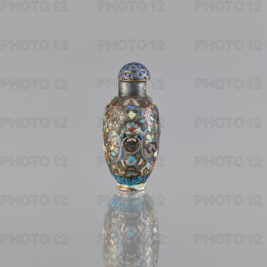 Snuffbox with stopper, cloisonné enamel, Chinese, figural scenes and plant ornament, handles; maker, ; vessel; China, 1929–1930; height 5.8 cm, width 4.8 cm., A small ornate object with rounded sides and a domed top sits centered against a plain light gray background; the object displays a metallic base color with decorative enamel-like patterns in shades of blue, turquoise, teal, gold, purple, and hints of brown, with a reflective surface beneath creating a mirrored reflection; the domed top features a lattice-like pattern highlighted in blue and gold, and the body shows raised ornamental motifs and swirled colorful accents in blue, turquoise, teal, gold, purple, and brown.