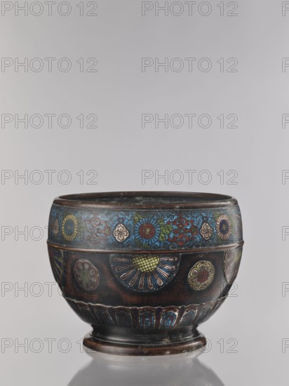 Flowerpot, Shimasa role classification of creator, workshop author, Japanese art, Japanese culture, flowerpots, Meiji 1868–1912, champlevé enamel, floral ornament, bronzes, jardinière, late 19th century Meiji period, Japan, vessel, height 30.4 cm, diameter 41.2 cm, A round metal bowl with a short pedestal base sits against a plain light gray background; the bowl has a dark brown and black patina with decorative bands of colorful floral motifs in blue, green, red, yellow, and pink, including a band near the rim of stylized flowers and swirling patterns in blue and red, a middle section featuring fan-shaped floral medallions in blue, yellow, green, and red set against a dark ground, and a lower band of repeating petal-like shapes in blue and red above the base.