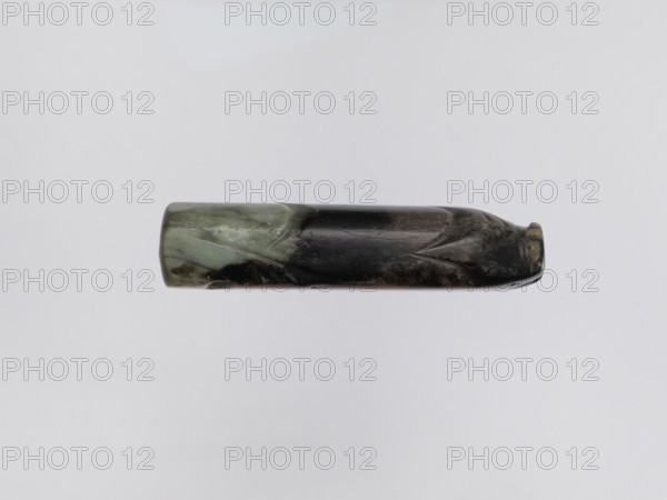 Pig — funerary figurine; creator, Chinese; Han dynasty 202 BCE–220 CE; jade; animal subject pig, zodiac sign; full sculpture/figurine; 2nd century BCE–3rd century CE; China; height 2.2 cm, width 9.5 cm, depth 2.4 cm, weight 0.12 kg., A horizontal cylindrical object with a smooth, polished surface displaying a mix of black, dark gray, greenish, and pale green colors, with glossy highlights and subtle irregular streaks and patches; the left end is more greenish while the right end is darker and slightly tapered, and the surface shows shallow carved or etched linear grooves and faint textured marks against a plain light gray background.