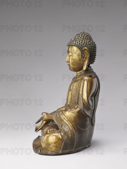 Shakyamuni Buddha, Chinese, Qing dynasty 1644–1911, 17th–18th century. Bronze sculpture of Shakyamuni Buddha with ushnisha; Chinese Buddhism iconography including tutelary deities and Buddha iconography. Height 47.0 cm; width 26.0 cm., A seated statue of a meditative figure shown in profile with a calm facial expression, closed eyes, elongated earlobes, and tightly curled hair; the figure wears flowing robes with decorative patterns visible on the fabric and the hands rest in a gesture near the lap; the surface shows a metallic finish with worn areas revealing a golden color alongside darker bronze and brown tones, and the background is a smooth gray gradient.