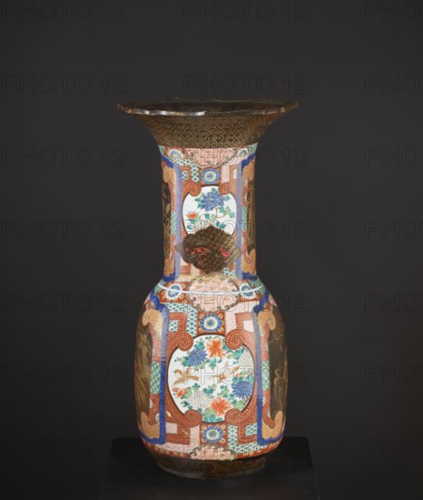 Vase, Japanese, birds, pines, ceramics, geometric decorations, vases, vase bases, decorative vessels, colored porcelain, Meiji 1868–1912, high, wide neck with a large flaring cup-like rim; rim with a variegated cut. Decorated with multicolored enamels in the background and in the white reserves; fields covered with black lacquer decorated with gold, red, and gray-blue lacquer; part in flat relief. c. 1880–1900, Japan; vessel. Height 79.0 cm; diameter 38.5 cm., A tall decorative vase with a flared rim sits against a dark background, displaying a rich palette of colors including red, blue, green, orange, gold, white, brown, and black; the vase features ornate patterned panels and cartouche-like white areas filled with floral and bird motifs in blues, greens, oranges, and browns, surrounded by intricate geometric and scrolling designs in red, gold, and blue, with additional areas of dark metallic brown decorated with fine gold patterns, all resting on a dark base.