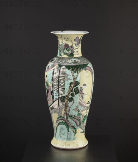 Vase, park scenes with architecture, enamel paints, Chinese art, Chinese culture, ceramics, decorative vessel, signed, 19th century, China, vessel, height 59.5 cm, diameter 25 cm, A tall ceramic vase with a flared rim standing against a dark background, decorated in pale yellow, light green, mint, dark green, purple, white, and black tones; the body shows painted scenes including a gnarled tree with dark green foliage, rocky formations in mint and green, architectural elements like railings and bridges in pale green and purple, and human figures wearing garments in green, purple, and white; the neck features floral and botanical motifs with blossoms in purple and green on a yellow ground, and a decorative band with floral medallions in green and purple encircles the shoulder.