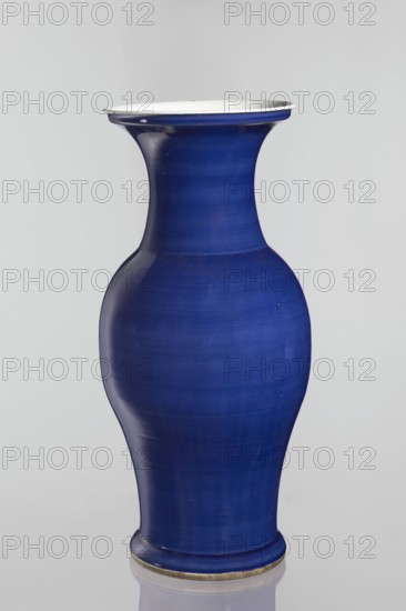 Vase, Chinese, decorative vessel, Qing style, ceramic, 19th century Qing dynasty, 1644–1911, China; vessel; height 62.5 cm, diameter 28.5 cm, A tall vase with a curving silhouette, featuring a narrow neck that flares at the rim and a rounded body tapering toward the base, glazed in deep blue with subtle tonal variations and a glossy finish; the rim interior and a thin band at the top edge are white, and a narrow metallic band appears at the base; the background is light gray.