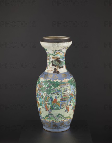 Vase, colored porcelain with figurative scenes and plant ornaments, depicting warriors and knightly scenes and pumpkins; Qing dynasty Tongzhi, 1862–1874, 2nd half of the 19th century; foot and arms decorated with applied/plastic decorations; vessel; height 62.5 cm, diameter 26.5 cm; China., A tall ceramic vase with a flared neck and rounded body standing against a dark gray background, predominantly showing colors including white, blue, green, red, brown, gold, and black. The neck area is mostly white with painted green and brown decorative elements and a dark brown band at the rim. The body features a blue band near the top and bottom with gold decorative motifs, and a central scene painted in green, blue, red, and brown tones depicting a landscape with trees, rocky hills, and a group of figures arranged around architectural elements, bridges, and a pavilion. There are areas of raised brown and green textured decoration near the neck, and the base sits on a flat black surface.