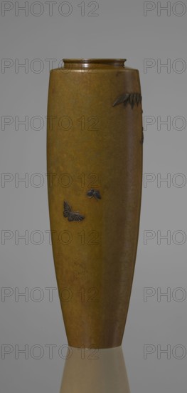 Vase, Nogawa role classification of creator, repossession Krakow — wisteria, butterflies, Japanese art, vases, Japanese culture, Meiji 1868-1912. A slender miniature vase, with a belly widening slightly towards the top and narrow, straight arms. There is no neck, and the spout is in the form of a flat ring. The bottom is round, slightly recessed, with an engraved brand. The decoration is sparse, consisting of a naturalistically treated wisteria vine placed in the upper part of the belly on one side, from which a sumptuous flower cluster hangs down, almost to the end of the vase. Thanks to the masterly technique of combining various metals and alloys in one work, characteristic of Japanese craftsmanship of that period, the vessel gained colorfulness, enhanced by the darker tone of the decorative motif than the background. Although made of silver, thanks to the use of gilding and black shakudo patina, it is also colorful, enhancing the effect of fidelity to nature in the depiction of the...