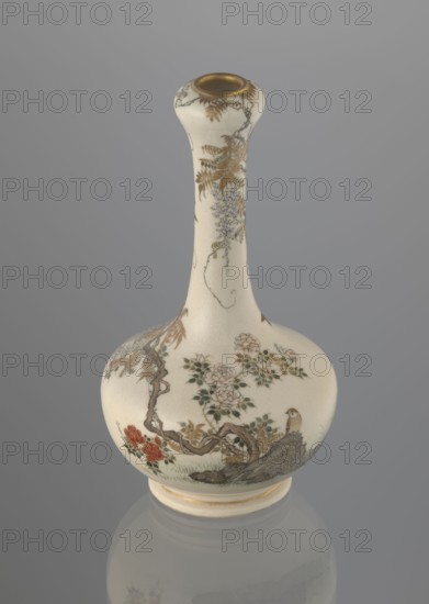 Vase, Yabu Meizan 1853–1934. Onion-shaped vase on a low ring foot with a long, slender neck bulging at the spout. Decorated with a freely composed kachôga flowers-and-birds motif: a golden-leafed wisteria vine with white blooms entwines the neck, growing from the rock on which a sparrow perches; a tall rose bush with white and red blooms stands beside the wisteria; two sparrows painted in gold and iron black fly around the plants. A small, delicately hatched black-and-gold ornament is placed in the lower part of the belly. Warm milky glaze with very fine cracklework; thin gold stripe around the foot and gilded rim. Gold-painted signature in a square cartouche with three kanji characters: Yabu Meizan. c. 1900 Meiji 33, Osaka, Japan. Ceramic vessel; height 15.0 cm, diameter 8.0 cm., A pale cream-colored ceramic vase with a long narrow neck and a rounded body stands against a soft gray background; the surface is decorated with delicate painted botanical motifs in shades of muted gold, sof...