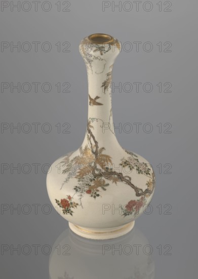 Onion-shaped vase with a low ring foot and long slender neck bulging at the spout, decorated with a freely composed kachôga flowers-and-birds motif: a small, delicately hatched black-and-gold ornament on the lower belly; a golden-leafed wisteria vine with white blooms entwining the neck, growing from a rock on which a sparrow perches; a tall rose bush with white and red blooms beside the wisteria; two sparrows painted in gold and iron black flying around the plants. Warm milky glaze with very fine cracklework, thin gold stripe around the foot and gilded rim. Gold-painted maker’s mark at the base in a square cartouche with three kanji characters: Yabu Meizan. Meiji period, c. 1900 Meiji 33. Satsuma ceramics, Japanese; Osaka. Height 15.0 cm, diameter 8.0 cm. Maker: Yabu Meizan 1853–1934. Function: vessel., A cream-colored ceramic vase with a long narrow neck and bulbous base sits against a gray background; the vase has painted floral and vine motifs in gold, brown, green, and red, with d...