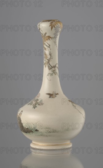 Vase, Yabu Meizan 1853–1934, c. 1900 Meiji 33, Japan, Osaka. Onion-shaped vase on a low ring foot with a long slender neck bulging at the spout. Decorated with a freely composed kachôga flowers-and-birds motif: a golden-leafed wisteria vine with white blooms entwines the neck, growing from the rock on which a sparrow perches; a tall rose bush with white and red blooms grows beside the wisteria. Two sparrows, painted in gold and iron black, fly around the plants. A small delicately hatched black-and-gold ornament is placed on the lower belly. Warm milky glaze with very fine crackle; thin gold stripe around the foot and gilded rim. Gold-painted brand on the base in a square cartouche with three kanji characters: Yabu Meizan. Ceramic vessel; height 15.0 cm, diameter 8.0 cm., A pale cream ceramic vase with a long slender neck and rounded body sits against a gray background, decorated with delicate painted botanical motifs in muted gold, brown, green, and pale purple; a few small birds are ...