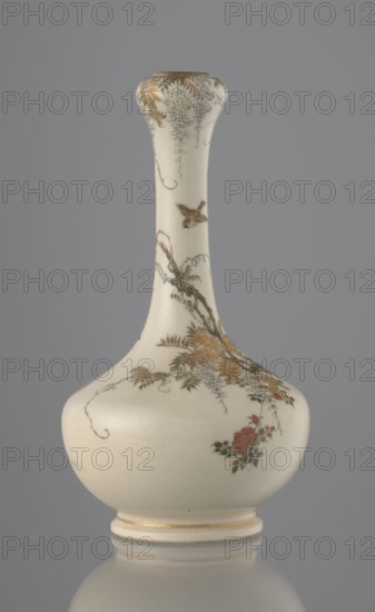 Vase, Yabu Meizan 1853–1934, c. 1900 Meiji 33, Japan, Osaka. Onion-shaped vase on a low ring foot with a long, slender neck bulging at the spout. Decorated with a freely composed kachôga flowers-and-birds motif: a small, delicately hatched black-and-gold ornament in the lower belly; a golden-leafed wisteria vine with white blooms entwining the neck and growing from a rock where a sparrow perches; a tall rose bush with white and red blooms beside the wisteria; two sparrows painted in gold and iron black flying around the plants. Warm, milky glaze with very fine cracklework; thin gold stripe around the foot and gilded rim. Gold-painted maker’s mark at the bottom in a square cartouche with three kanji characters: Yabu Meizan. Ceramic vessel, height 15.0 cm, diameter 8.0 cm., A pale cream porcelain vase with a long narrow neck and rounded body sits against a gray background; the surface shows fine craquelure and delicate painted decoration including a small bird in flight, floral clusters,...