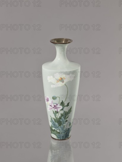 Vase, poppies; Japanese art; Japanese culture; flowers iconography; Meiji–Taisho period, ca. 1910–1920 Meiji 1868–1912 / Taisho 1912–1926; cloisonné enamel; Nagoya, Japan; vessel; height 24.5 cm, diameter 9.0 cm., A tall, narrow ceramic vase with a flared neck and metallic rim sits against a plain gray background, painted in pale mint green with a botanical motif showing a group of stylized flowers and foliage; the flowers include a large white bloom with a subtle yellow and blue center and a few smaller purple blossoms, and the leaves and stems are rendered in various shades of green and bluish-green, with the metallic rim and base showing a bronze tone and a soft reflection visible on the surface beneath the vase.