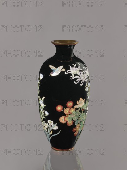 Vase, chrysanthemums, roses; Japanese art; Japanese; flowers; Meiji 1868–1912, ca. 1900; Japan, Nagoya; vessel; height 24.4 cm, diameter 11.7 cm, A tall, glossy black vase with a narrow neck and flared rim sits against a neutral gray background, decorated with painted floral motifs and a small bird. The painted flowers include clusters of red-orange blossoms with yellow centers, pale pink and white blooms, and long, slender green leaves, along with a larger pale lilac chrysanthemum-like flower. A small bird with white, pale blue, and light yellow feathers and a darker head is depicted in flight near the neck. The vase has a thin reddish-gold band around the rim and a matching band at the base, and its surface reflects light, creating highlights on the glossy black finish.