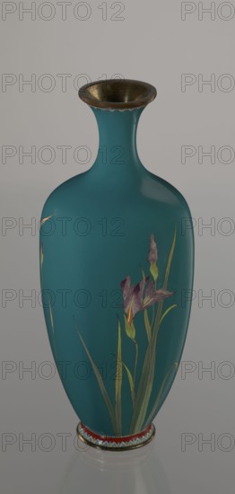 Vase, cloisonné enamel, ovoid vase one of a pair, slender, on a low ring-shaped foot and a narrow neck, flaring at the rim; foot and mouth framed with sheet metal. Decorated with a motif of a blooming iris bush rendered with naturalistic fidelity and varied color tones. Executed using the yusen technique, motif placed against a uniform sea-green background. Narrow colorful borders around the foot and rim made with yusen, composed of small triangular forms called cicada wings. Japanese, Meiji period, ca. 1900; Nagoya. Vessel. Height 25 cm; width 9.7 cm; depth 8.8 cm., Gift; repossession noted., A teal-colored vase with a flared metallic rim and a narrow neck that widens into an elongated rounded body, decorated with painted purple flowers and green leaves, sitting on a base band that includes red and a patterned row of blue and white, all shown against a soft gray background.