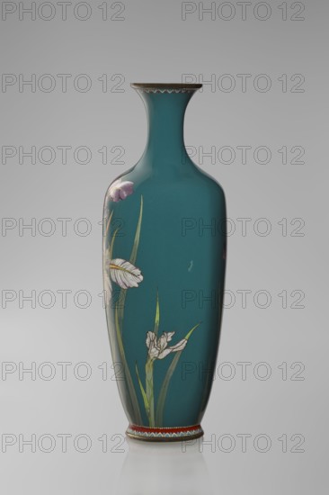 Vase, ovoid one of a pair, slender, on a low ring-shaped foot with a narrow neck flaring at the rim; foot and mouth framed with sheet metal. Decorated with a motif of a blooming iris bush rendered with naturalistic fidelity and varied color tones. Executed using the yusen technique against a uniform sea-green background; narrow, colorful borders around the foot and rim also made with yusen, composed of small triangular forms called cicada wings. Cloisonné enamel. Meiji period, ca. 1900., Nagoya, Japan. Vessel. Height 25 cm; width 9.7 cm; depth 8.8 cm., A tall, slender vase with a narrow neck and flared rim, finished in a deep teal color, decorated with floral motifs including pale white and light purple blossoms and long green leaves, with a decorative band of red, blue, white, and gold near the base and a subtle scalloped gold trim under the rim; the surface appears glossy and reflective against a neutral gray background.