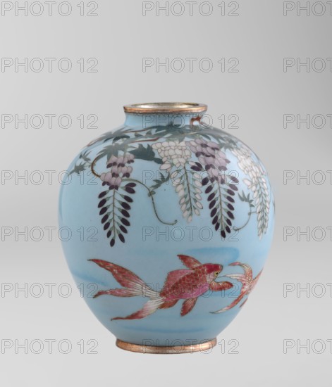 Vase by Gonda Hirosuke 1865–1937, enameller. Small spherical cloisonné enamel vase, one of a pair, on a low ring foot and a round ring spout, both set in silver-plated metal. Decorated with realistically depicted colorful red veil fish beneath hanging wisteria leaves and flowers on a light blue background. Bottom bears a flaming-pearl brand with the katakana character yu — Gonda Hirosuke’s maker’s mark. Circa 1890–1910 Meiji period, Nagoya, Japan. Height 9.0 cm; diameter 8.2 cm., A rounded ceramic vase with a pale blue background, featuring a decorative band of hanging floral clusters and leaves in shades of white, pale purple, dark purple, and green near the top, and a pair of stylized fish in shades of pink and red with pale fins along the body; the rim and base have metallic accents in a warm gold tone, and the overall palette includes pale blue, pink, red, purple, green, white, and gold.