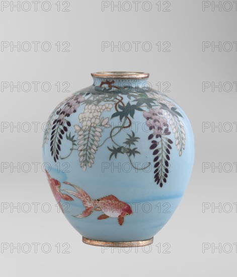 Vase by Gonda Hirosuke 1865–1937, cloisonné enamel, circa 1890–1910 Meiji period. Small spherical vase, one of a pair, on a low ring foot and a round ring spout, both set in silver-plated metal. Decorated with a realistic, colorful motif of red veil fish beneath hanging wisteria leaves and flowers on a light blue background. The base bears a flaming pearl mark with the character yu in katakana, the enamelist's mark; Gonda worked in Nagoya. Japan, Nagoya. Height 9.0 cm; diameter 8.2 cm., A rounded ceramic vase with a pale blue background decorated with hanging floral clusters and leafy vines in shades of white, purple, dark green, and muted brown, and a pair of reddish-orange fish with pinkish scales and golden accents near the lower portion; the rim and base show metallic-looking bands in a warm gold tone.