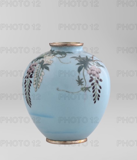 Vase, Gonda Hirosuke 1865–1937 maker. Small spherical cloisonné enamel vase, one of a pair, on a low ring foot and a round ring spout, both set in silver-plated metal. Decorated with a realistically depicted, colorful motif of red veil fish beneath hanging wisteria leaves and flowers on a light blue background. The bottom bears a brand in the form of a flaming pearl with the character yu in katakana — the mark of enameller Gonda Hirosuke of Nagoya. Circa 1890–1910 Meiji 23–43, Nagoya, Japan. Vessel; height 9.0 cm, diameter 8.2 cm., A rounded vase with a pale blue body and metallic rim, decorated with a floral motif showing hanging clusters of elongated petals and leaves in shades of dark purple, lavender, white, and green, with greenish stems and tendrils extending across the surface; the background and base area remain pale blue with subtle darker blue shading.