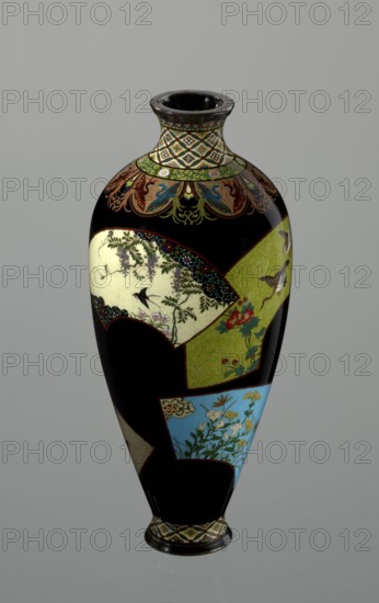 Vase by Namikawa Yasuyuki 1845–1927, ca. 1890–1905 Meiji period. Small, slender cloisonné enamel vase, height 18.0 cm, diameter 7.8 cm. Body tapers toward the bottom to a ring-shaped silver foot; arms merge into a short neck slightly parted at the spout, enclosed by a silver ring. Ornamental shippo cloisonné border with rosettes in rhomboid fields at the foot and a similar neck border. Petal decoration filled with stylized phoenix images flows down to the shoulders. Belly is glossy black enamel with six colorful fan-shaped reserves decorated with floral and bird motifs in the yusen technique with silver wires. Silver plaque with engraved signature mounted in the mirror of the bottom: Kyoto Namikawa. Origin: Kyoto, Japan., A tall vase with a glossy black background decorated with a few panels in cream, green, and blue showing floral and bird motifs, a patterned neck and base with geometric designs in green, cream, and brown, and additional decorative accents in red, gold, and turquoise.