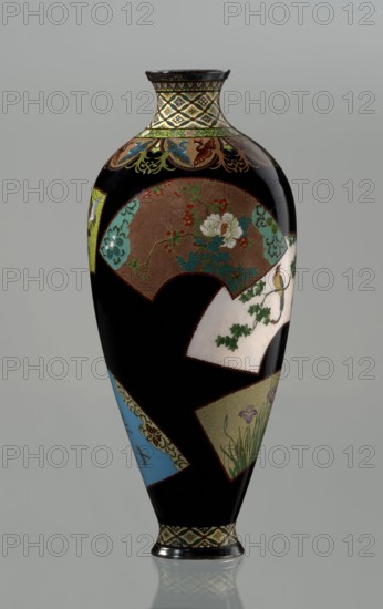 Vase by Namikawa Yasuyuki 1845–1927, cloisonné enamel, ca. 1890–1905 Meiji period. A small, slender vase tapering toward the bottom and terminating in a ring-shaped silver foot. The top arms merge into a short neck slightly parted at the spout, enclosed by a silver ring. An ornamental shippo cloisonné border with rosettes in rhomboid fields decorates the foot and neck; petals filled with stylized phoenix images flow down to the shoulders. The belly has glossy black enamel with six colorful fan-shaped reserves showing various floral and bird motifs, executed in the yusen technique with silver wires. A silver plaque with an engraved signature reading Kyoto Namikawa is mounted in the mirror of the bottom. Kyoto, Japan. Height 18.0 cm; diameter 7.8 cm., A tall, oval-shaped decorative vase with a glossy black background covered in a patchwork of fan-shaped panels containing floral and botanical motifs, showing colors including black, brown, white, green, blue, yellow, red, teal, purple, and...