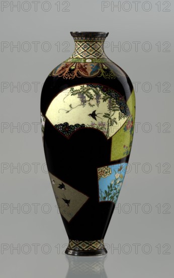 Vase by Namikawa Yasuyuki 1845–1927, ca. 1890–1905 Meiji period, 1868–1912, Kyoto, Japan. Small, slender cloisonné enamel vase, height 18.0 cm, diameter 7.8 cm, with body tapering to a ring-shaped silver foot and a short neck with a spout enclosed by a silver ring. Ornamental shippo cloisonné border with rosettes in rhomboid fields at the foot and a similar ornament on the neck. Petal decoration filled with stylized phoenix images flows down to the shoulders. Belly covered in shiny black enamel with six colorful fan-shaped reserves depicting floral and bird motifs, executed in the yusen technique with silver wires. Silver plaque mounted in the mirror of the bottom engraved: Kyoto Namikawa., A tall, slender vase with a glossy black background and a narrow neck, decorated with several inset panels showing floral and bird scenes; the neck and base have patterned bands in cream, green, and gold, and the upper shoulder features ornate curving motifs in green, red, blue, and gold. One large ...