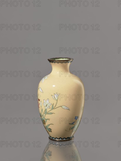 Vase, unknown creator; ; decorated with flowers and birds; Japanese cloisonné enamel; Meiji period, ca. 1900; Japan; vessel; height 12.2 cm, diameter 7.1 cm., A smooth, rounded vase with a narrow flared neck and a glossy finish in pale yellow is shown against a neutral gray background, decorated with delicate floral motifs in white, green, blue, and touches of pink and red, and with dark brown edging at the rim and base; the vase sits on a reflective surface that mirrors its lower portion.