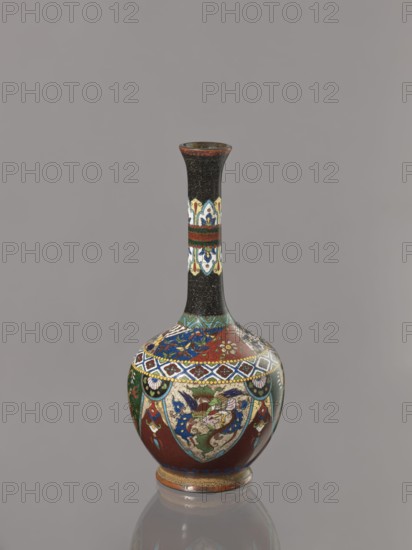 Vase, Japanese, Meiji period 1868–1912, ca. 1900. Cloisonné enamel vessel decorated with birds, dragons, and phoenixes. Height 19.3 cm, width 8.9 cm., A narrow-necked vase with a bulbous body stands against a plain gray background, featuring a predominantly black neck with intricate small circular patterns and a decorative band of cream, blue, red, and green near the middle, while the rounded body displays rich areas of red, green, blue, cream, and gold in ornate floral and geometric motifs, accented with dark outlines and small touches of white, and the vase sits on a short foot ring showing bands of gold and reddish-brown.