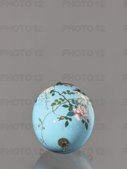 Vase, Japanese, Meiji–Taisho period ca. 1910–1920, cloisonné enamel, kachôga bird-and-flower motif depicting wisteria, roses, and swallows; vessel; height 20 cm, diameter 15.3 cm., A smooth oval object with a glossy light blue surface occupies the lower center of the image, decorated with painted green leaves, pale pink flowers, thin brown vines, and a small bird rendered in soft colors; there is a small round metallic fixture attached near the bottom of the object and a faint reflection of the object is visible on the flat grey surface below, while the background is a uniform muted grey.