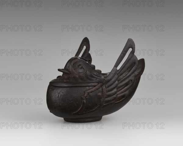 Duck incense burner, Chinese, Qing 1644–1911, 19th century, China; subject: ducks/birds with wings; material: vessel used as an incense burner; dimensions: height 9.7 cm, width 13.6 cm., A dark brown sculptural vessel shaped like a stylized bird with a rounded body and a lid forming the bird's head and beak, featuring raised wing-like ornaments on the sides and cutout elongated shapes in the upright tail elements, set against a neutral gray gradient background with lighter gray near the bottom.