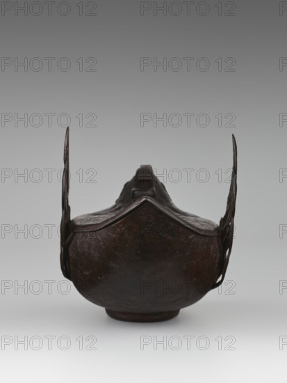 Duck incense burner, Chinese, Qing 1644–1911, 19th century, porcelain vessel in form of ducks with wings, function: incense burner, height 9.7 cm, width 13.6 cm, subject: ducks birds., An object resembling a dark brown, rounded metal vessel with a raised rim and a pointed front edge, flanked by two thin vertical extensions on either side; the surface appears uneven and textured with darker and lighter brown variations, and the background is a smooth gradient of gray transitioning from a darker gray at the top to a lighter gray near the bottom.
