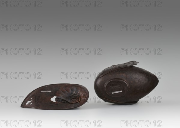 Duck incense burner, Chinese, Qing dynasty 1644–1911, 19th century. Ceramic vessel in the form of a duck with wings, used as an incense burner; height 9.7 cm, width 13.6 cm. Subjects: ducks/birds. Provenance unknown., A group of two dark brown metal objects rests on a light gray surface against a gradient gray background, one object lying on its side with an oval, slightly pointed shape and a raised circular area on its side, and the other object shown interior-side up with a concave form, organic curved ridges, and a few cutout shapes; the colors visible include dark brown, rust tones, and shades of gray.