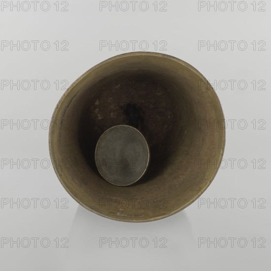 Bell, Islamic art, Persian culture, Qajar dynasty 1785–1925, figurative motifs, animals lions, camels, deer, 19th century, Iran; varia; height 26.5 cm, diameter 15.0 cm, A large round metallic object photographed from above showing its hollow interior with a smaller round piece suspended near the center; the visible colors include shades of brown, dark brown, muted gray, and hints of greenish-bronze, with a pale gray background.