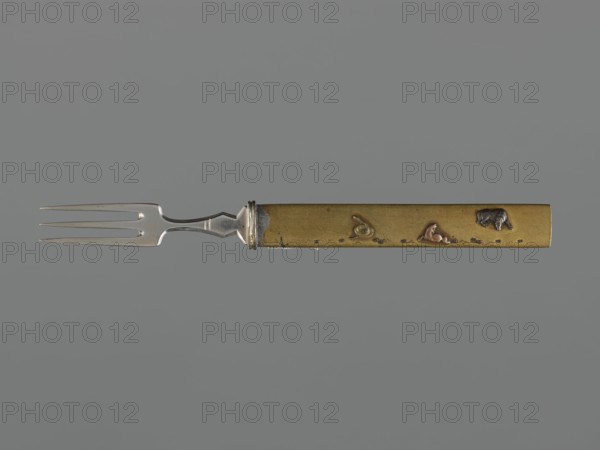 Fork with knife handle kozuka, maker, kozuka, 18th century Edo period, 1603–1868, Japan. Materials: applied plastic decoration depicting grazing horses and a snake. Subject/iconography: snakes, horses; function: kozuka for katana swords cutlery/knife handle. Dimensions: height 17 cm, width 0.9 cm, depth 0.6 cm., A three-pronged metal fork attached to a straight rectangular handle, the metal prongs and neck are silver-colored with a slightly reflective finish, and the handle is brass-colored with small raised decorative shapes in darker and reddish tones; the background is a uniform mid-gray.