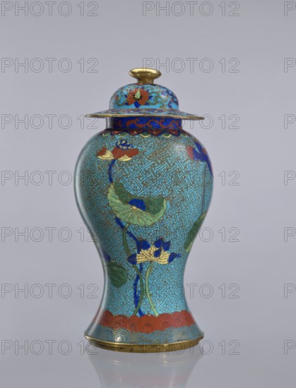 Vase with cover., Cloisonné enamel baluster vase with lotuses. Qing dynasty 1644–1911, 18th century. China. Height: 37 cm. Gift; provenance: Ignacy Jan Paderewski., A lidded vase with a rounded body and flared base and rim, predominantly turquoise blue with an all-over geometric maze-like pattern, decorated with floral motifs including lotus leaves and blossoms in green, blue, gold, and red, with accents of dark blue and teal; the lid has similar floral decoration and a gold knob, and there are bands of red and gold near the neck and base.