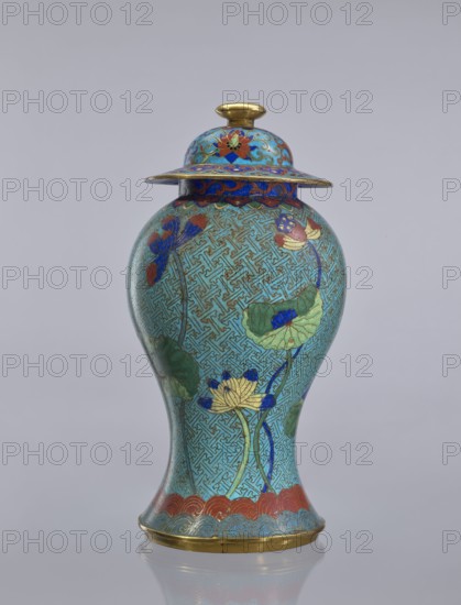 Vase with cover, Chinese, Qing dynasty 1644–1911, cloisonné enamel, decorated with lotuses and geometric patterns, decorative vessel, 18th century China, height 37 cm, A tall, rounded vase with a lid, primarily turquoise in color with intricate geometric line patterns covering its surface, decorated with floral motifs in shades of blue, green, red, and gold; the lid has a domed top with a small gold knob and a flared rim with blue and red ornamentation, the body shows lotus-like flowers and large green leaves outlined in gold, and the base features a scalloped band in red and blue with a thin gold rim.
