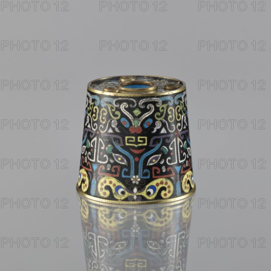 Sawdust container, Paderewski, Ignacy Jan 1860-1941, Chinese art, Chinese culture, Qing dynasty 1644–1911, cloisonné enamel, decorated with fantastical beasts and cicadas, base with four inserts, 19th century, China; vessel, height 8.5 cm, diameter 9.7 cm., A small conical object sits on a reflective surface, showing a detailed surface covered in intricate swirling and geometric patterns. The object features a dominant black background with ornamental lines and shapes in bright colors including blue, yellow, red, green, white, and touches of purple and gold. Gold metal rims appear at the top and bottom edges, and the top has a circular opening with a gold inner ring and a blue interior. The decorated surface includes symmetrical motifs and curving forms, and the reflection beneath shows a mirrored image of the same colors and patterns.
