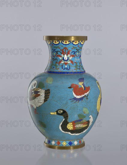 Vase, : Paderewski, Ignacy Jan 1860–1941. Chinese art; Chinese; Qing dynasty 1644–1911. Cloisonné enamel decorative vessel vase on a foot with a neck. Decoration: ducks on a turquoise background; lotus tendril on the neck. 19th century. China. Height: 23.5 cm., A rounded vase with a narrow neck and flared rim sits against a plain pale gray background, decorated in bright colors on a predominantly turquoise-blue ground; the neck features stylized floral motifs in red, white, green, dark blue, and gold with a gold rim at the top, while the body shows a pattern of concentric wave-like lines in darker blue and several painted ducks in colors including black, yellow, red, white, green, and blue, along with green leaf shapes; a decorative band with diamond shapes in red, blue, yellow, white, and gold encircles the base, which also has a gold edge.