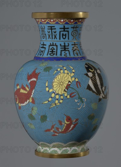 Vase, Chinese, Qing dynasty 1644–1911, 19th century. Cloisonné enamel on metal; vessel on a foot with a neck. Decoration: fish and crabs on a turquoise background, archaizing inscription on the neck. Height 23.2 cm; diameter 9.1 cm., A rounded vase with a narrow neck and flared rim sits against a neutral gray background, predominantly glazed in bright blue with gold accents; the rim and base edges are metallic gold and the neck features a band of deep blue and a few darker blue decorative borders. The body shows a pattern of swirling wave lines in darker blue over the bright blue ground, with a group of stylized aquatic creatures including a yellow crab with red claws, several red fish with white and gold details, and a black fish with gold and white accents, along with a few green leaf-like elements and pale green wave motifs near the base.